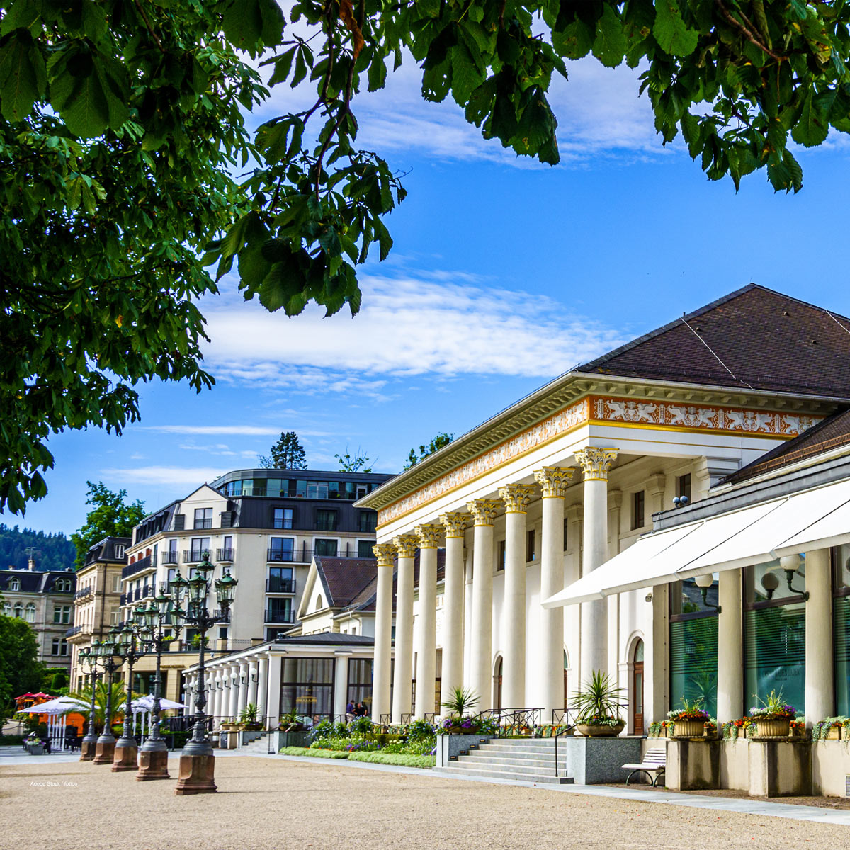 Klassizistisches Gebäude mit Säulenvorbau, Spaziergänger im Vordergrund. Kurhalle Baden-Baden.