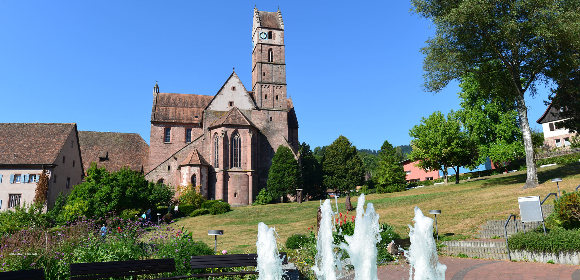 Historische Kirche Kloster Reichenbach mit Türmen und Wasserspielen im gepflegten Park.
