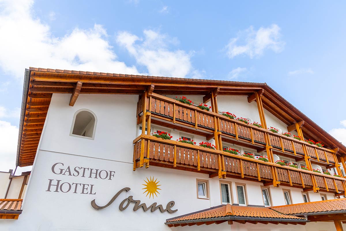 Außenansicht mit Fassade des Hotels und Schriftzug „Gastliches Hotel Sonne“ auf weißem Putz.